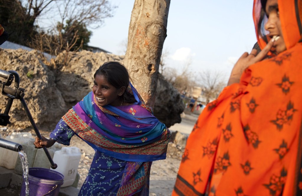 a young woman uses a hand pump to fill water for daily use near her home at a katchi abadi in islamabad photo muhammad saqib