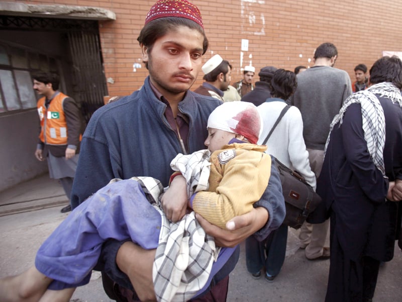 a man carries his injured brother as he waits for treatment at peshawar s lady reading hospital photo reuters