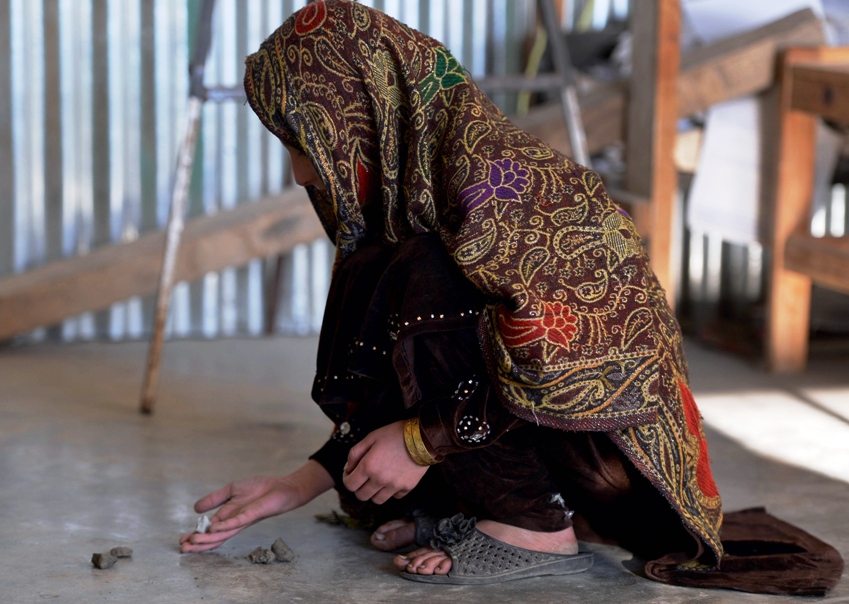 in this photograph taken on december 12 2013 young pakistani girl saneeda who escaped a forced marriage under a local custom of swara plays a local game in the madyan valley of swat photo afp