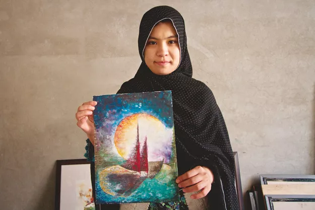a student at the sketch club displays her painting of a boat that depicts the horrors that confront hazara asylum seekers escaping to australia photos danial shah a student at the sketch club displays her painting of a boat that depicts the horrors that confront hazara asylum seekers escaping to australia photos danial shah