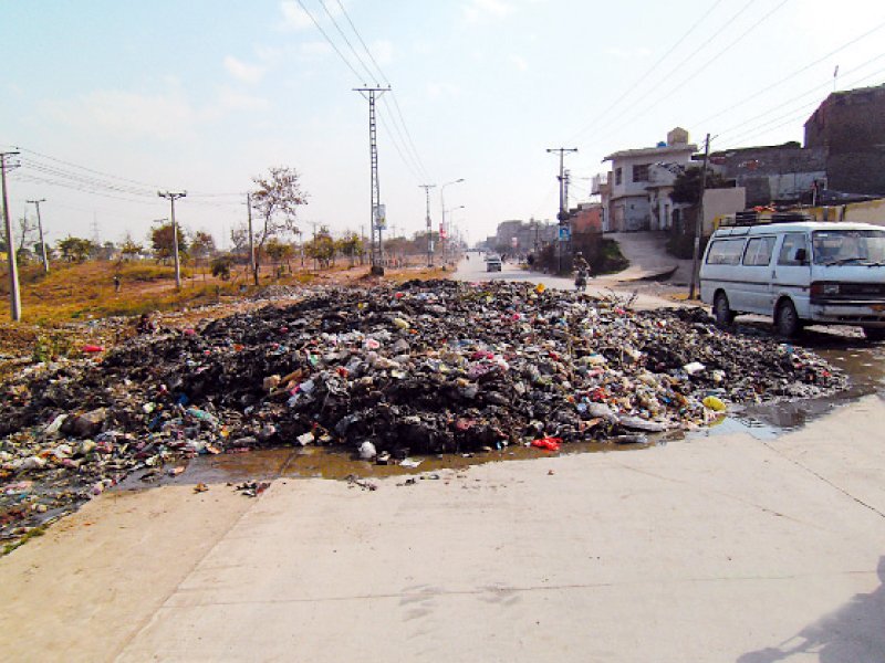 a pile of garbage that has left less than one lane of the road usable left photo kashif abbasi