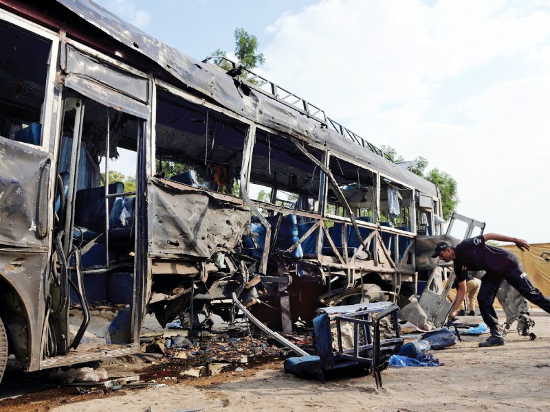 a police officer inspects the wreckage of the police bus at the site of a bomb attack in karachi photo reuters