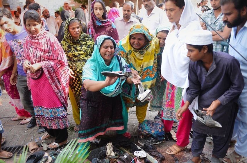 people look at discarded clothing and shoes as they mourn the death of suicide bombing victims at all saints church in peshawar on september 24 2013 photo afp