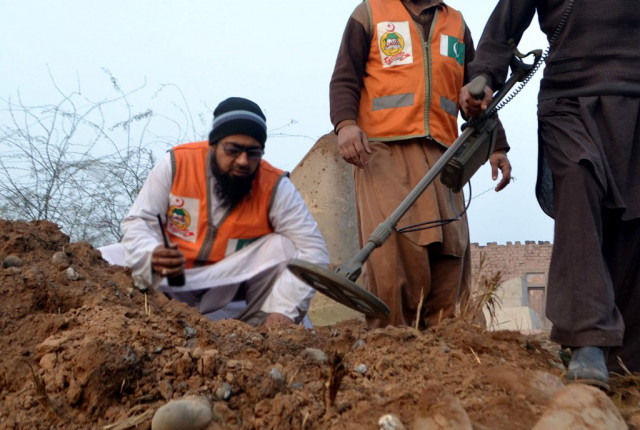 policemen collect evidence after a remote controlled bomb exploded near the van of a polio vaccination team in budhni on the outskirts of peshawar on february 16 2014 photo afp policemen collect evidence after a remote controlled bomb exploded near the van of a polio vaccination team in budhni on the outskirts of peshawar on february 16 2014 photo afp