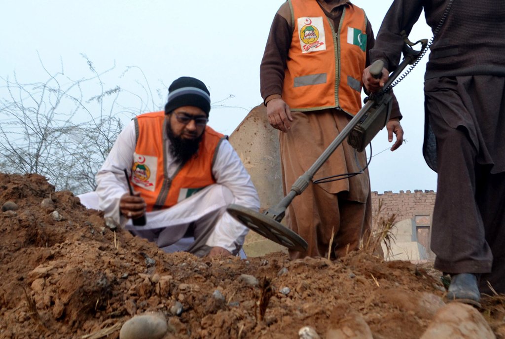 policemen collect evidence after a remote controlled bomb exploded near the van of a polio vaccination team in budhni on the outskirts of peshawar on february 16 2014 photo afp