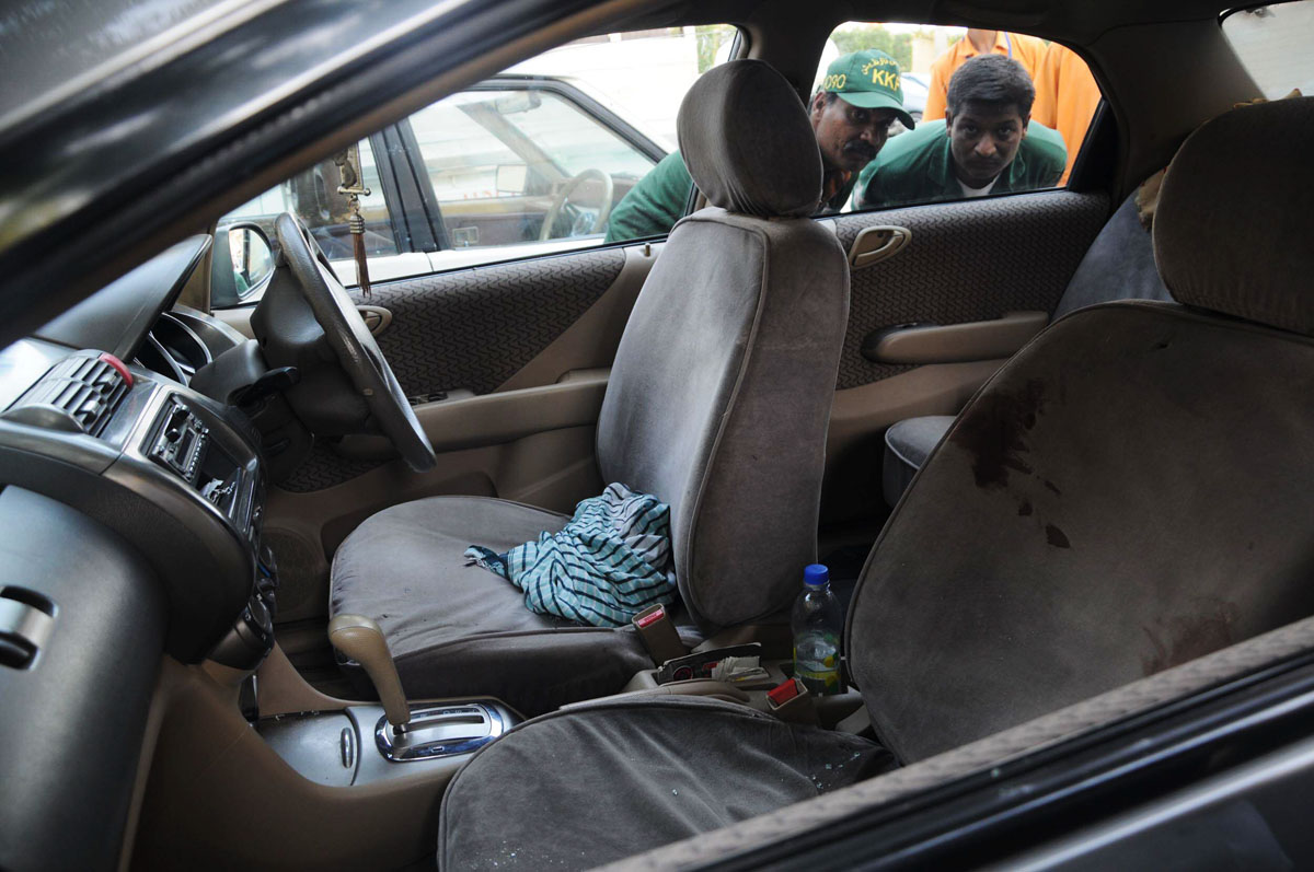 rescue workers peek through the window of the car in which javed iqbal kazi was killed photo mohammad noman express
