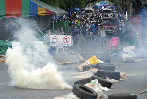 thai anti government protesters run from tear gas after police demanded for them to leave the area around the government house in bangkok on february 18 2014 photo afp