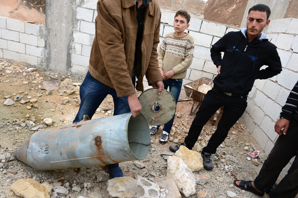 a syrian man shows a cluster bomb that releases or ejects smaller sub munitions in the northern syrian town of taftanaz in the idlib province photo afp file