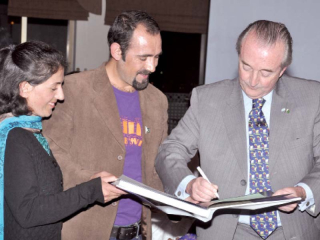 ambassador saravia signs a diary as baig and ali look on photo express ambassador saravia signs a diary as baig and ali look on photo express