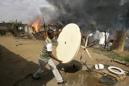 in this file photo a man tries to save his belongings during anti immigration clashes east of johannesburg south africa photo reuters file