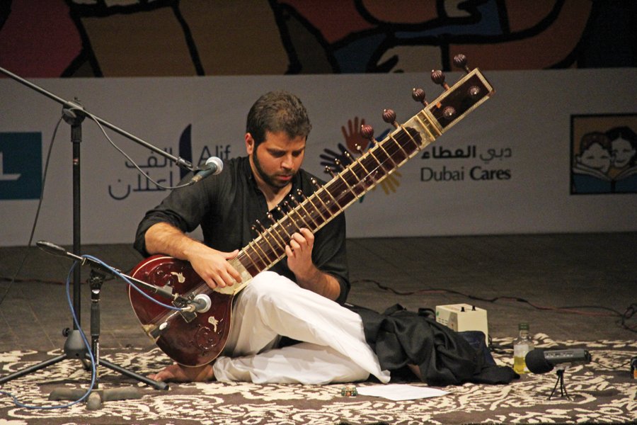 a musician performs the clf anthem humein kitaab chahiye written by zehra nigah on the first day of the festival the audience were handed out sheets of paper with the lyrics of the anthem and were encouraged to sing along