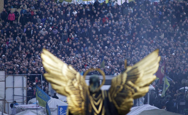 people listen to speeches in front of a statue in independence square in kiev february 21 2014 as a peace deal was signed photo reuters