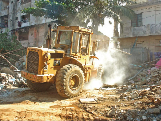 a bulldozer crushes illegal constructions in karachi a 1 500 square yard plot in gulistan e jauhar was clearly marked as a park in the neighbourhood s master plan but nearly five years ago some residents built houses over the land photo file a bulldozer crushes illegal constructions in karachi a 1 500 square yard plot in gulistan e jauhar was clearly marked as a park in the neighbourhood s master plan but nearly five years ago some residents built houses over the land photo file
