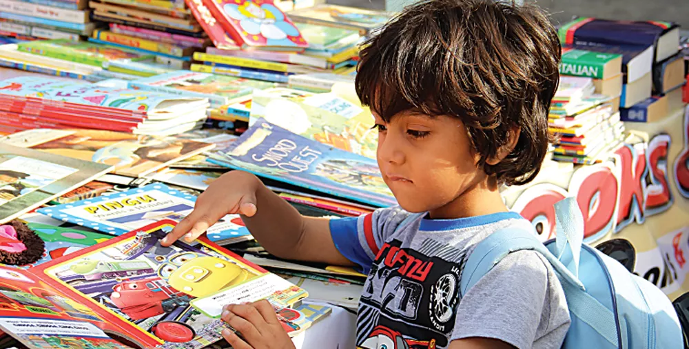 a child skims through a book at one of the book stalls at the children s literature festival photo ayesha mir express a child skims through a book at one of the book stalls at the children s literature festival photo ayesha mir express