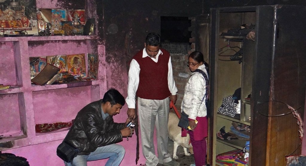 in this photograph taken on february 20 2014 investigators take photographs at the charred residence where accused indian auto rickshaw driver bunty sharma immolated himself after killing his wife us national arian willingar from pennsylvania in agra photo afp