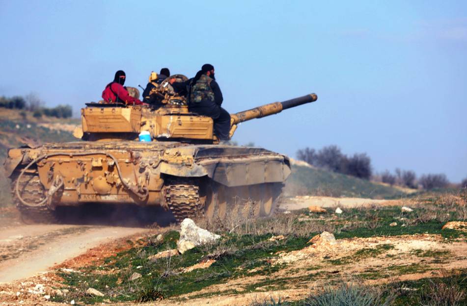 rebel fighters sit on top of a tank as they head to the front line of battles against syrian pro government forces near the city of hama on february 18 2014 photo afp