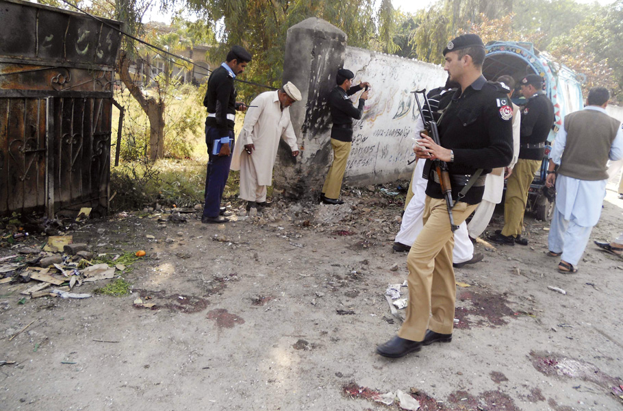 security officials examine the site of the bomb blast in kohat on sunday photo reuters