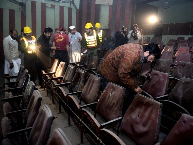 volunteers and security officials investigate the cinema after the attack photo afp file