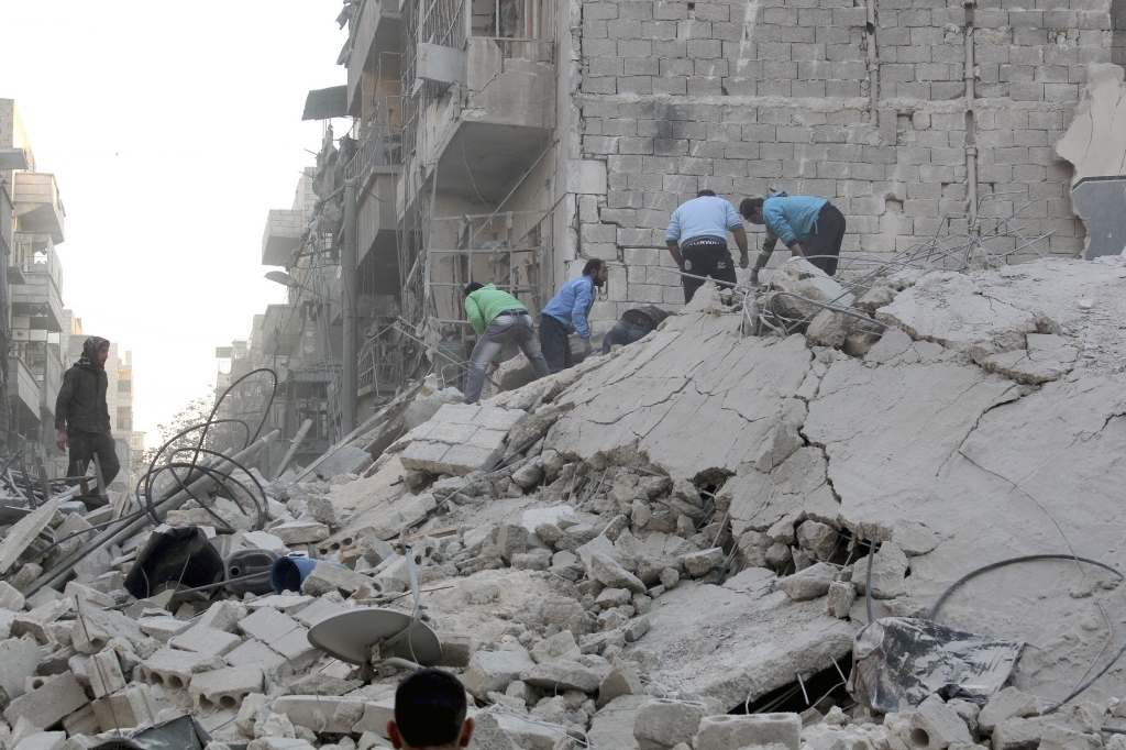 people stand on rubble of damaged buildings at a damaged site in syria photo reuters