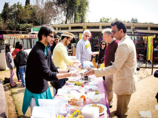 a youngster serves food to a customer at the bazaar photo express
