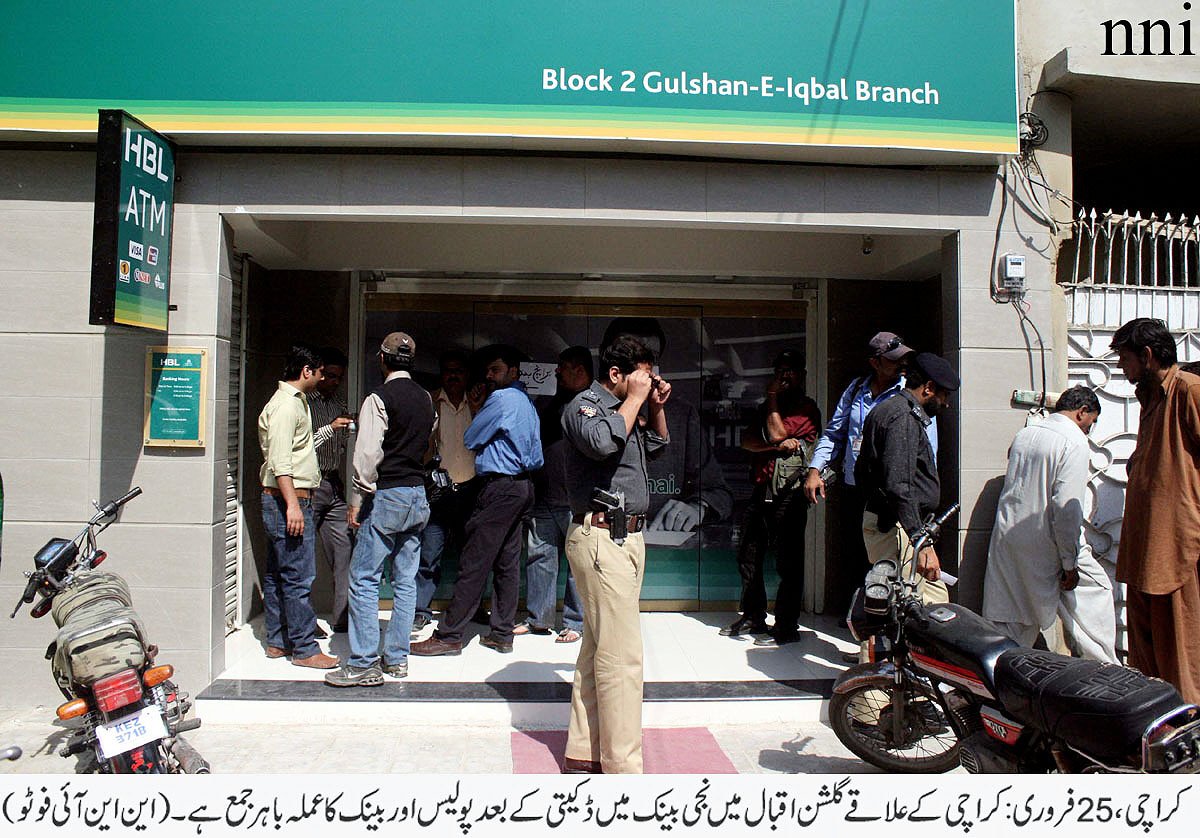 police officials stand outside the bank branch which was looted on tuesday photo nni