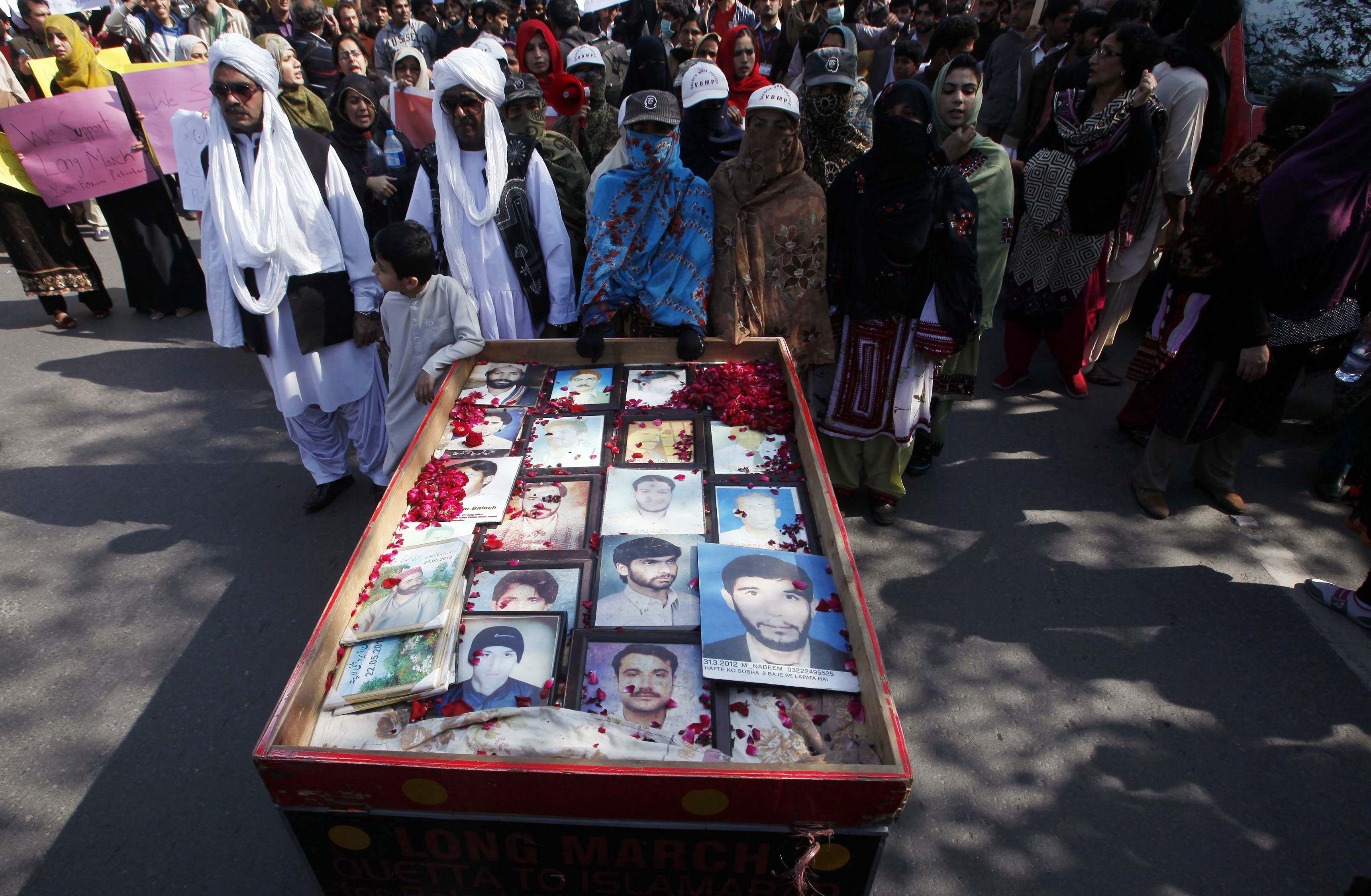 family members place portraits of their missing relatives on a push cart upon their arrival after a long march from karachi to lahore february 12 2014 photo reuters