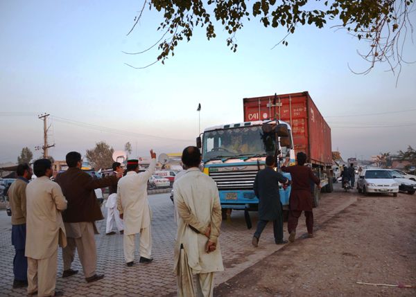 pti supporters stop a truck to check the documents at an unofficial checkpoint in a bid to block the nato supply trucks in peshawar on december 4 2013 photo afp