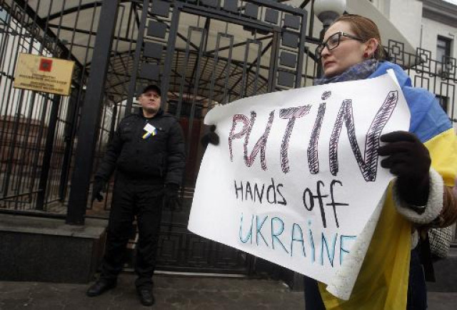 a woman holds a sign during a demonstration in front of the russian embassy in kiev on saturday photo afp