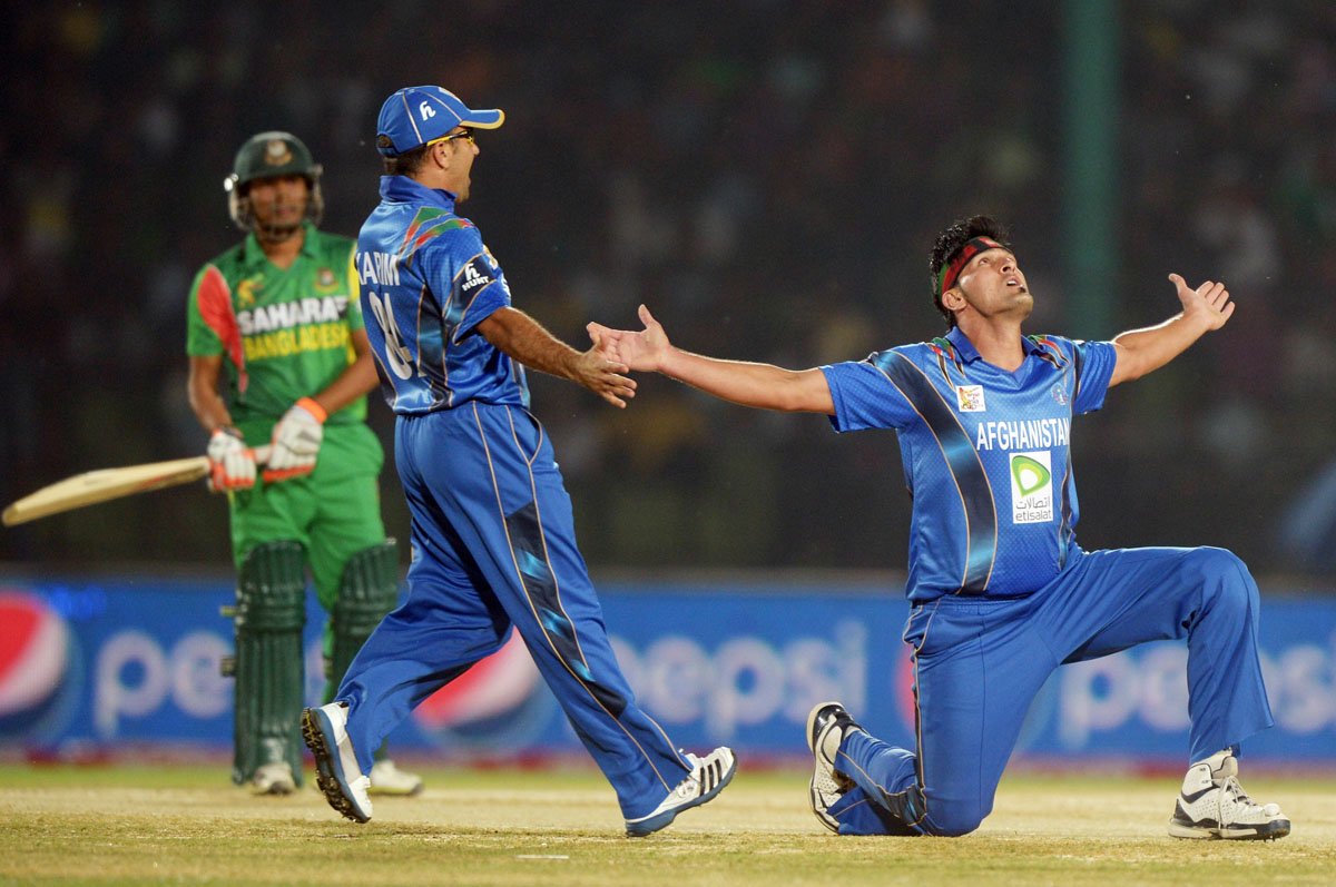 afghan bowler hamid hassan r with teammate karim sadiq celebrates after taking the wicket of bangladeshi batsman anamul hoque bijoy during the fifth match of the asia cup one day cricket tournament between bangladesh and afghanistan at the khan shaheb osman ali stadium in fatullah on the outskirts of dhaka on march 1 2014 photo afp