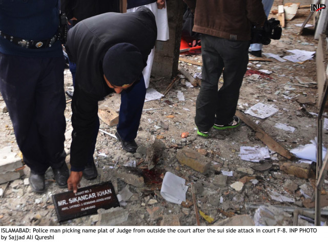 a police man picking up the name plate of a judge from the ground after the suicide attack at district and session court in islamabad on monday march 3 2014 photo inp a police man picking up the name plate of a judge from the ground after the suicide attack at district and session court in islamabad on monday march 3 2014 photo inp