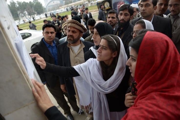 pakistani people look for the names of relatives from a list displayed outside the hospital in islamabad photo afp