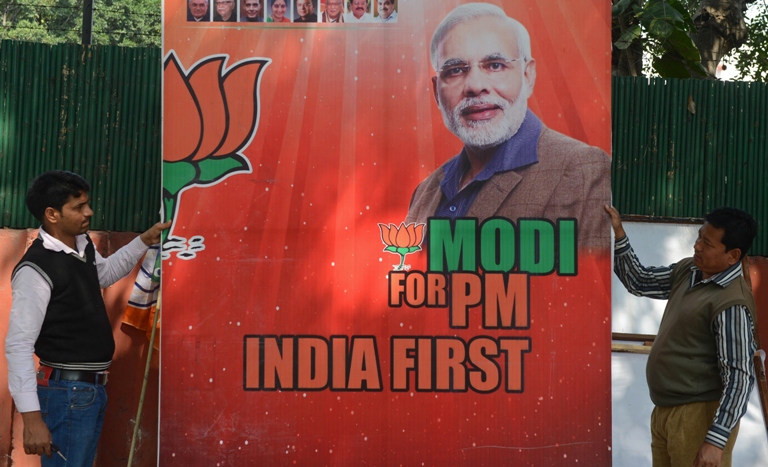 workers erect a billboard bearing the portrait of india 039 s opposition bharatiya janata party bjp prime ministerial candidate narendra modi in new delhi photo afp