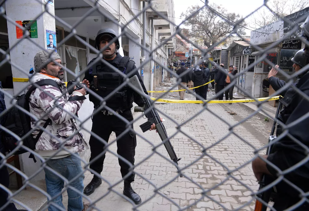 a police commandos stop a photo journalist near a local court building after a gun and suicide attack in islamabad on march 3 2014 photo afp a police commandos stop a photo journalist near a local court building after a gun and suicide attack in islamabad on march 3 2014 photo afp