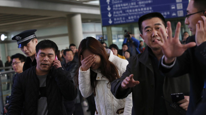 a relative of a passenger onboard malaysia airlines flight mh370 covers her face as she cries at the beijing capital international airport on march 8 2014 photo reuters