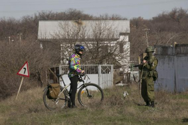 a uniformed man believed to be a russian servicemen talks to a cyclist near a ukrainian military base in sevastopol photo reuters a uniformed man believed to be a russian servicemen talks to a cyclist near a ukrainian military base in sevastopol photo reuters