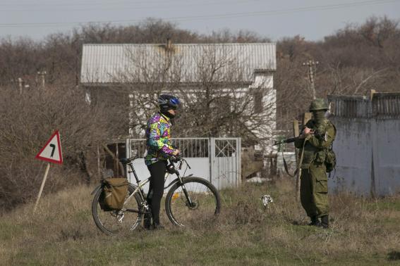 a uniformed man believed to be a russian servicemen talks to a cyclist near a ukrainian military base in sevastopol photo reuters