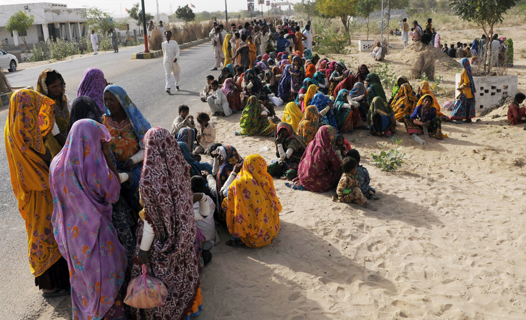 villagers wait to receive relief supplies outside a military camp in mithi the capital of tharparkar district some 300 kilometres from karachi on march 11 2014 photo afp