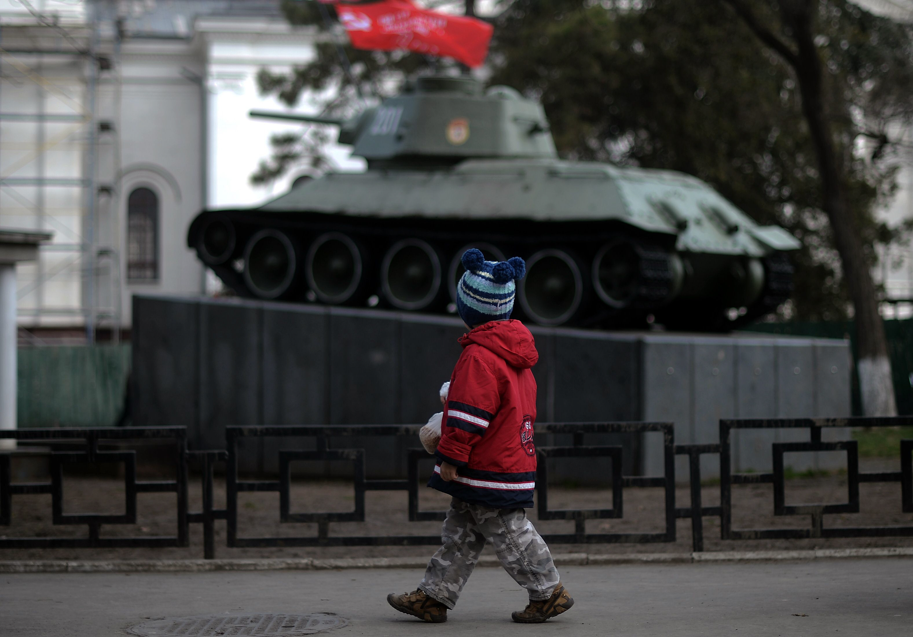 a child walks in front of a russian t 34 tank wwii memorial in front of crimea 039 s regional parliament in simferopol on march 12 2014 pro moscow lawmakers in crimea voted for independence from ukraine on march 11 in a precursor to a referendum this weekend for the region to become part of russia photo afp