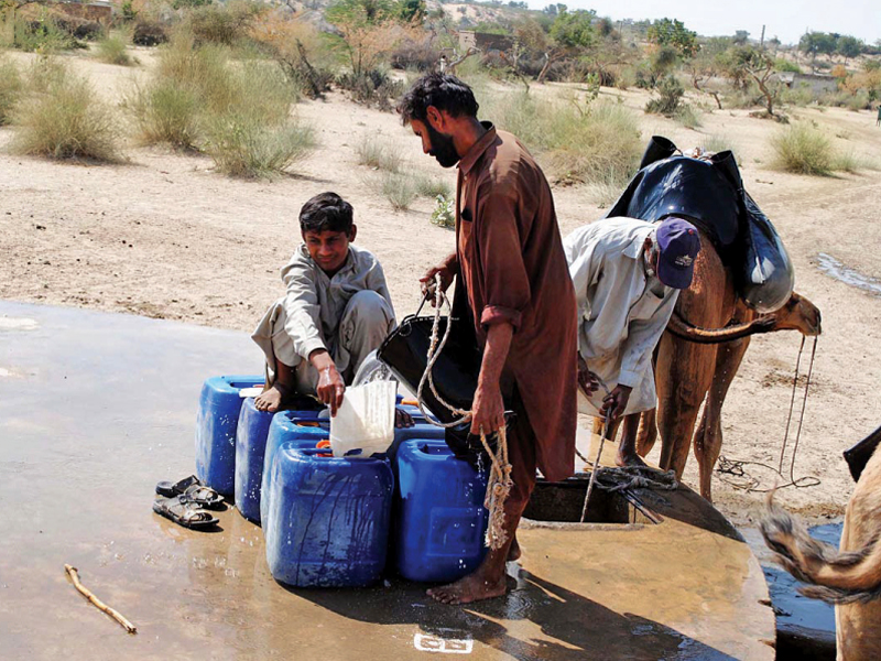 residents on the outskirts of mithi fill their cans with well water photo online