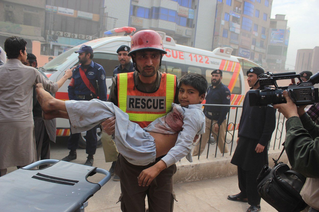 a rescue worker carries an injured child after the explosion that took place in the sarband area of peshawar on march 14 2014 photo muhammad iqbal express