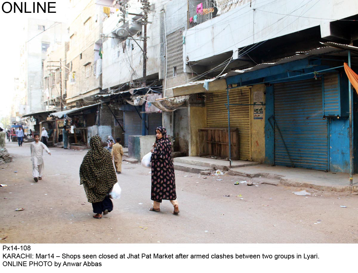 people walk past a closed jhat pat market in lyari on friday photo online