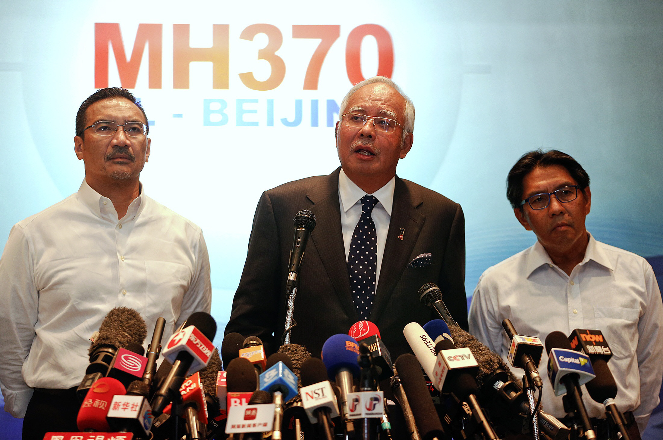 malaysian prime minister najib razak c addresses reporters about the missing malaysia airlines flight mh370 as transport minister hishammuddin hussein l and department of civil aviation 039 s director general azharuddin abdul rahman r stand by him at the kuala lumpur international airport photo reuters