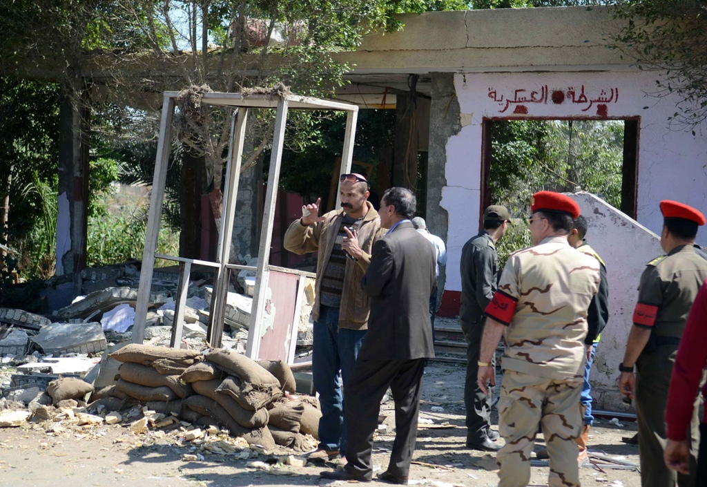 egyptian soldiers and officials inspect the sight where gunmen killed six soldiers at a cairo checkpoint on march 15 2014 photo afp