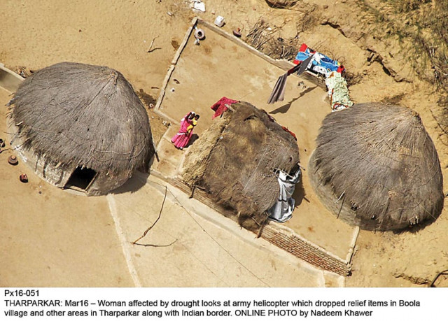 women living in drought hit tharparkar watch as the army helicopter drops relief items in boola village along the indian border photo online women living in drought hit tharparkar watch as the army helicopter drops relief items in boola village along the indian border photo online