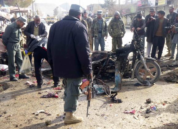 an afghan police officer stands at the site of a suicide blast in faryab northern afghanistan march 18 2014 photo reuters