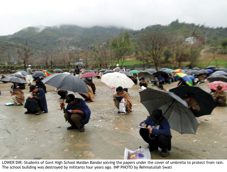 students of government high school maidan bandai lower dir take their exams outside in the rain with just an umbrella for cover photo inp