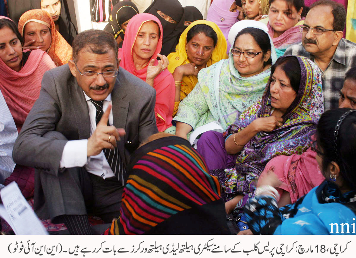 sindh health secretary iqbal hussain durrani speaks with protesting lady health workers outside the karachi press club on tuesday photo nni