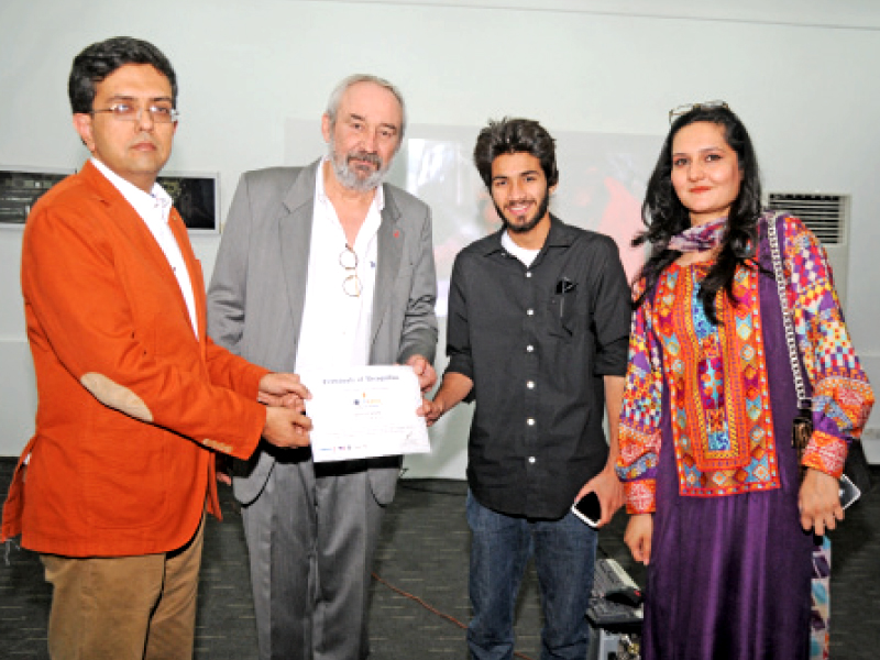 a participant of localens photography competition receives a certificate from the alliance francaise director on saturday photo ashraf memon express