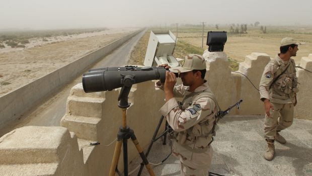 an iranian border guard looks through a pair of binoculars to monitor a border area in southeastern iran photo afp file
