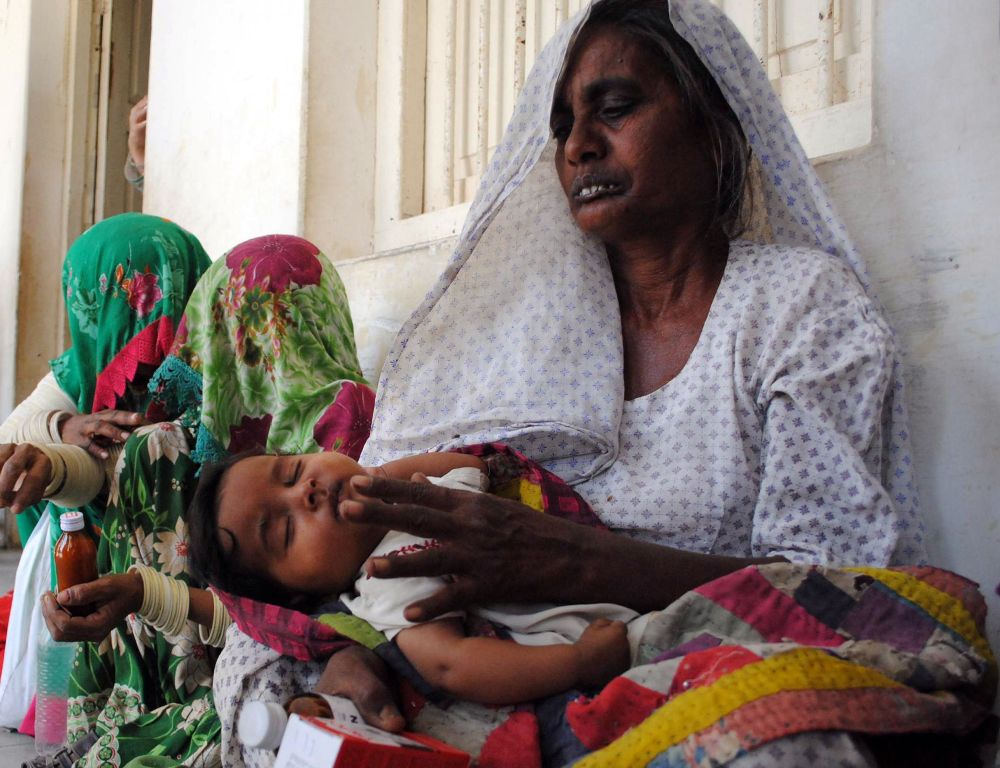 a villager tends to her sick child at a government hospital in the famine affected tharparkar district photo afp